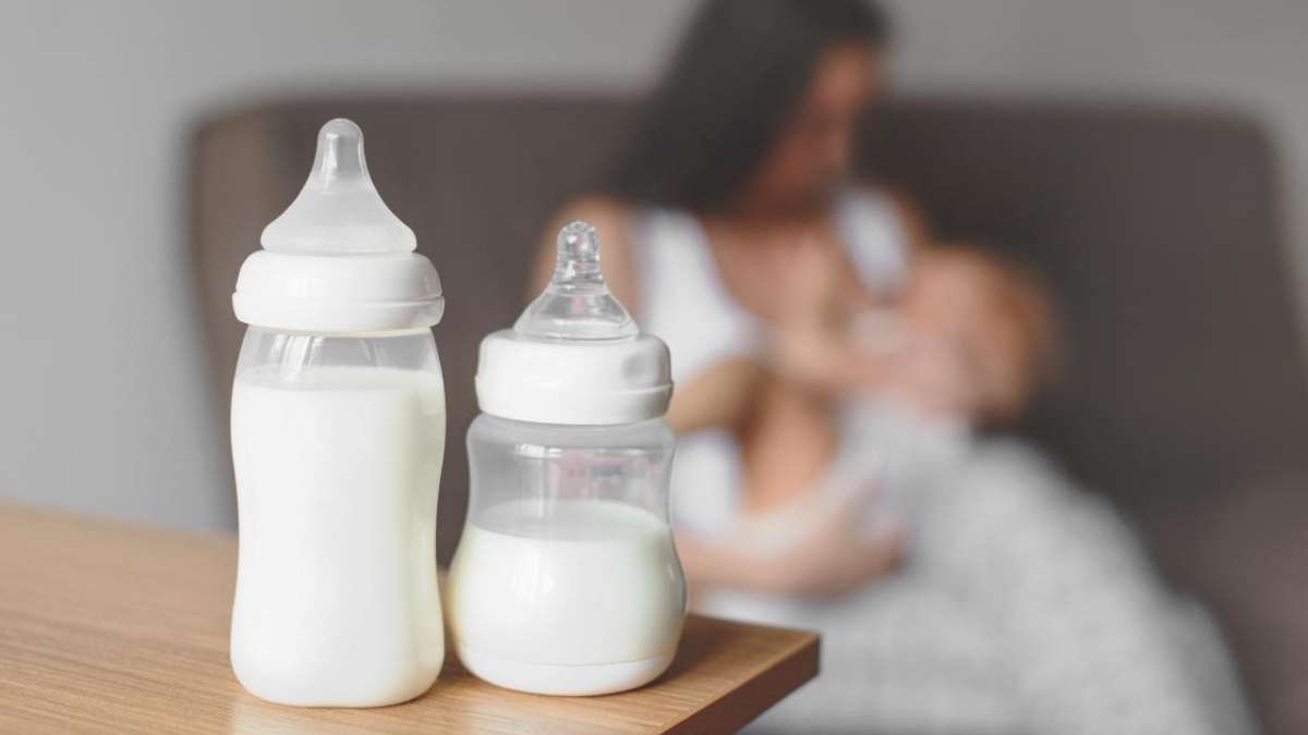 Dos biberones llenos de leche sobre una mesa, ilustrando la importancia de la leche en diferentes etapas de la vida, especialmente en el crecimiento y desarrollo de los más pequeños.